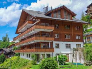 a large wooden building with balconies at Apartment Bella Vista-3 by Interhome in Wengen