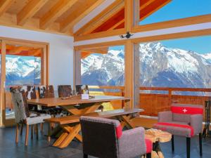 - une salle à manger avec une table, des chaises et des montagnes dans l'établissement Chalet Chalet Flocon de Neige by Interhome, à Plan Fey