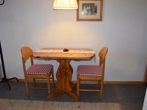 un tavolo in legno con 2 sedie e una lampada di Apartment Stöckli Studio by Interhome a Lenk