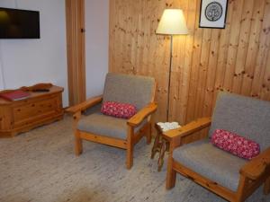 una stanza con due sedie, una lampada e un tavolo di Apartment Stöckli Studio by Interhome a Lenk