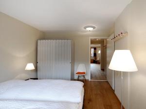 a bedroom with a white bed and two lamps at Apartment Gade A by Interhome in Lenk