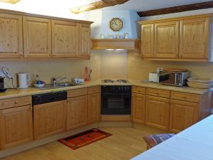 La cuisine est équipée de placards en bois et d'un four avec plaques de cuisson. dans l'établissement Apartment Chesa Frizzoni by Interhome, à Celerina