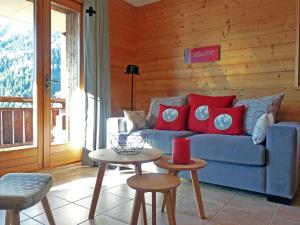 a living room with a blue couch with red pillows at Apartment Les Chalets de Marie A 22 by Interhome in Ovronnaz