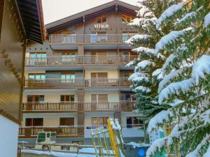 een hotelgebouw met sneeuw bedekte bomen ervoor bij Apartment Vitalis by Interhome in Zermatt