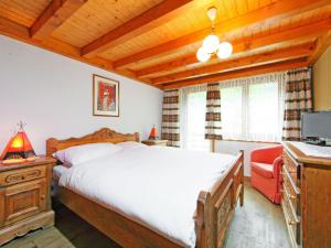 een slaapkamer met een bed, een bureau en een televisie bij Apartment Vitalis by Interhome in Zermatt