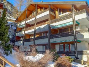 un bâtiment dans les montagnes avec de la neige au sol dans l'établissement Apartment Zen Stecken A by Interhome, à Zermatt