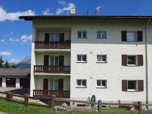 a white building with a fence in front of it at Apartment Chesa Vuorcha by Interhome in Zuoz