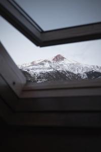 una ventana con vistas a una montaña cubierta de nieve en Albergue de Liri en Lirí