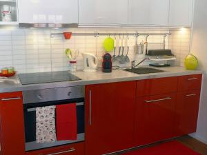 ベーヴァにあるStudio Chesa Rossa by Interhomeのキッチン(赤いキャビネット、シンク付)