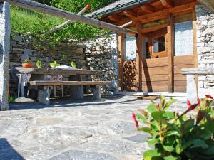 a picnic table in front of a stone building at Holiday Home Rustico Pamela by Interhome in Chiavasco