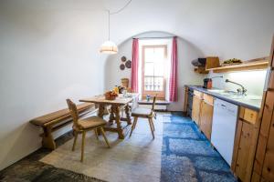 una cucina con tavolo, sedie e lavandino di Chesa Michel a Bever