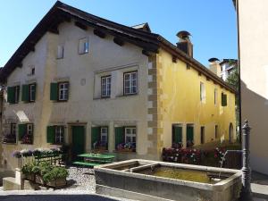 ein altes Haus mit einem Teich davor in der Unterkunft Apartment Chesa Stiffler Veglia I by Interhome in Pontresina