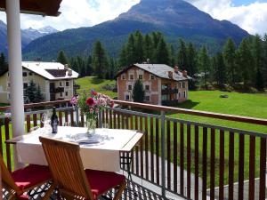 a table on a balcony with a view of a mountain at Apartment Chesa Vadret 12 by Interhome in Pontresina