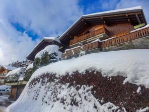 a snow covered yard in front of a house at Apartment Licorne 13 by Interhome in Verbier