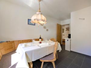 a dining room with a white table with a bottle of wine at Apartment Chesa Islas by Interhome in Pontresina +20 photos