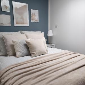 Appartement Mond في سنفتنبرغ: سرير بمخدات بيضاء وجدار ازرق