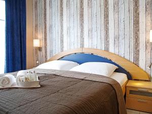 een slaapkamer met een bed met een blauw hoofdeinde bij Apartment Witthuus-Norderney by Interhome in Norddeich