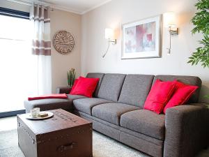 een woonkamer met een bank en rode kussens bij Apartment Witthuus-Norderney by Interhome in Norddeich