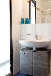 ノルトダイヒにあるApartment Witthuus-Norderney by Interhomeの白い洗面台と鏡のあるバスルーム