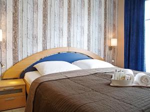 a bedroom with a large bed with a blue headboard at Apartment Witthuus-Juist by Interhome in Norddeich