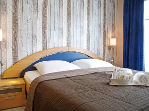 ノルトダイヒにあるApartment Witthuus-Juist by Interhomeのベッドルーム1室(大型ベッド1台、青いヘッドボード付)