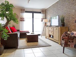 a living room with a couch and a tv at Apartment Witthuus-Juist by Interhome in Norddeich +22 photos