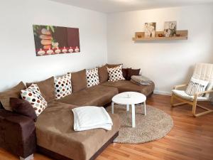 ein Wohnzimmer mit einem braunen Sofa und einem Tisch in der Unterkunft Holiday Home Hexenhuus by Interhome in Hage