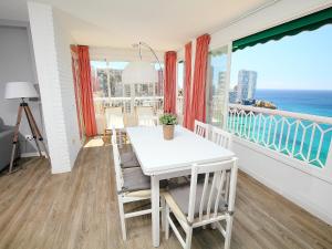 a white dining room with a view of the ocean at Apartment Torre Principado by Interhome in Benidorm