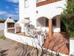 un patio de una casa blanca con mesa y sillas en Apartment Anfora 1 by Interhome, en Sant Martí d’Empúries