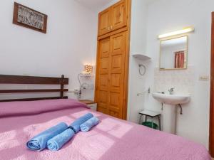 1 dormitorio con cama rosa y lavamanos en Apartment Anfora 1 by Interhome, en Sant Martí d’Empúries