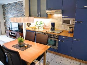 ノルトダイヒにあるApartment Witthuus-Borkum by Interhomeのキッチン(木製テーブル、青いキャビネット付)