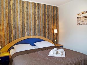 ノルトダイヒにあるApartment Witthuus-Borkum by Interhomeの木製の壁のベッドルーム1室(ベッド1台付)