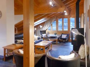 een woonkamer met een bank en een tafel en stoelen bij Apartment Chalet Pfingsteggblick by Interhome in Grindelwald