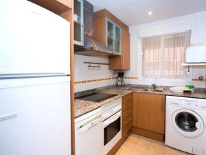 cocina con electrodomésticos blancos, lavadora y secadora en Apartment Jardines del Mar I-1 by Interhome, en El Borseral