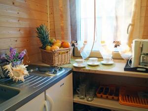 a kitchen with a sink and a basket of fruit at Holiday Home Villa Amber Gąski-2 in Gąski