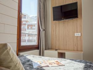 a bedroom with a window and a tv and a bed at Apartment Le Prariond - Val Claret-7 by Interhome in Tignes