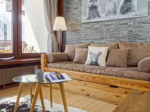 a living room with a brown couch and a brick wall at Apartment Le Prariond - Val Claret-7 by Interhome in Tignes