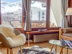 a living room with a couch and a large window at Apartment Le Prariond - Val Claret-7 by Interhome in Tignes