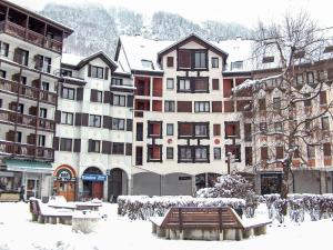 un gruppo di edifici nella neve con una panchina di Studio Gentiane-5 by Interhome a Chamonix-Mont-Blanc