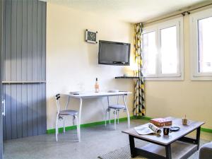 a room with a table and two chairs and a tv at Studio Gentiane-5 by Interhome in Chamonix-Mont-Blanc