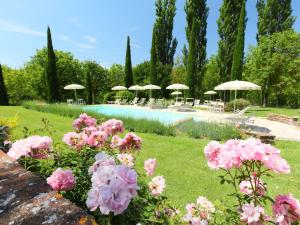 ラポラーノ・テルメにあるApartment Forno by Interhomeのピンクの花が咲く庭園、パラソル付きのプール