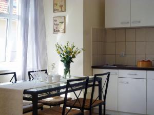 uma cozinha com uma mesa com um vaso de flores em Holiday Home Domek Joanna-3 by Interhome em Leba