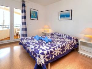 a bedroom with a bed with blue teddy bears on it at Apartment Maritim II by Interhome in Llança