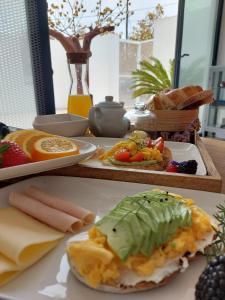 a table topped with plates of cheese and fruit at HOTEL S - ALOJAMENTO LOCAL in Castro Verde