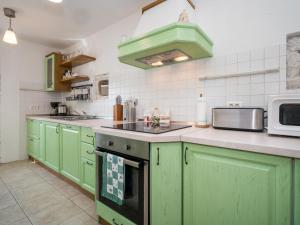 a kitchen with green cabinets and a microwave at Holiday Home Ivanka by Interhome in Čabrunići