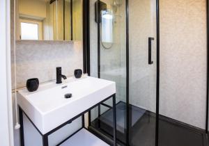 een badkamer met een witte wastafel en een douche bij James' Place at The Taff in Merthyr Tydfil
