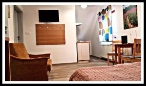 a hotel room with a bed and a television on the wall at Leśne Berdo 4 in Wetlina