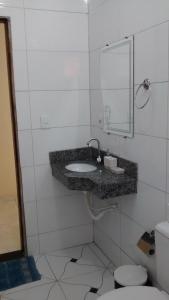 ein Badezimmer mit einem Waschbecken, einem WC und einem Spiegel in der Unterkunft Casa Temporada Juazeiro Bahia in Juazeiro