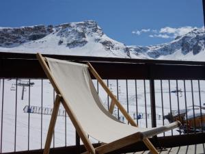 a chair on a balcony with a snow covered mountain at Studio Les Tommeuses - Val Claret-27 by Interhome in Tignes