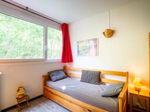 a small bedroom with a bed with a window at Apartment Les Lauzes-3 by Interhome in Les Menuires